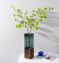 Walnut wood and smoked glass geometric vase with greenery