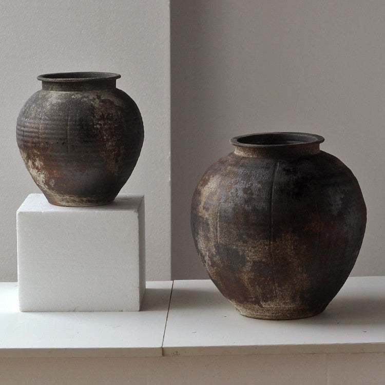 Large and medium rustic ceramic vases on pedestals