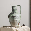 Tall weathered ceramic pitcher vase with handle