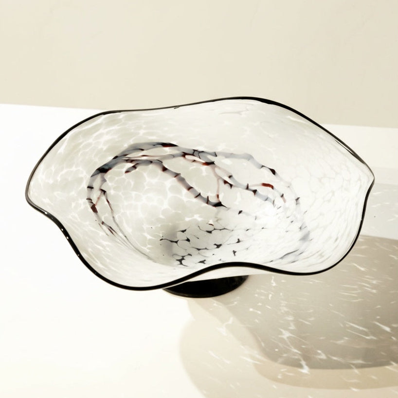 Top view of empty white and black marbled glass wavy bowl