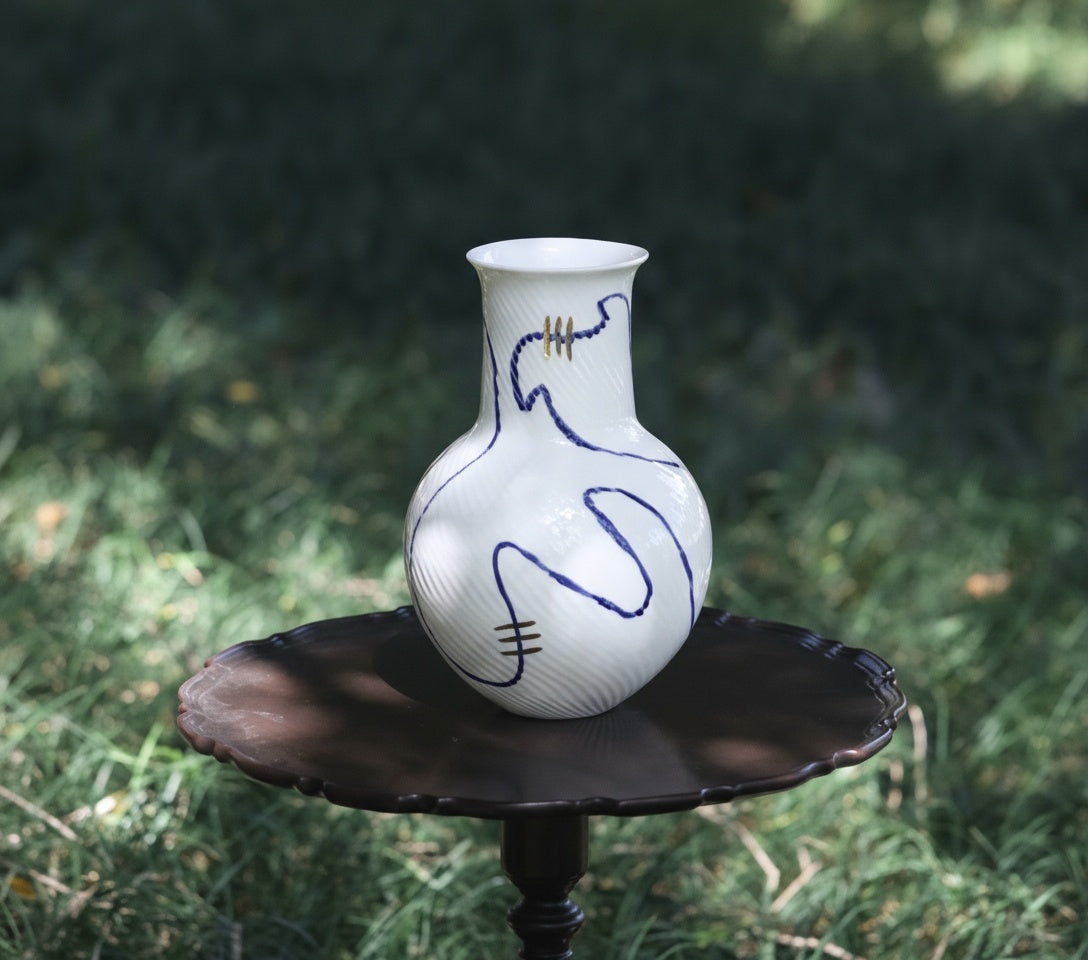 Alternate view of white ceramic vase showing textured surface and artistic line design