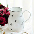 White Ceramic Botanical Handled Pitcher Styled With Flowers