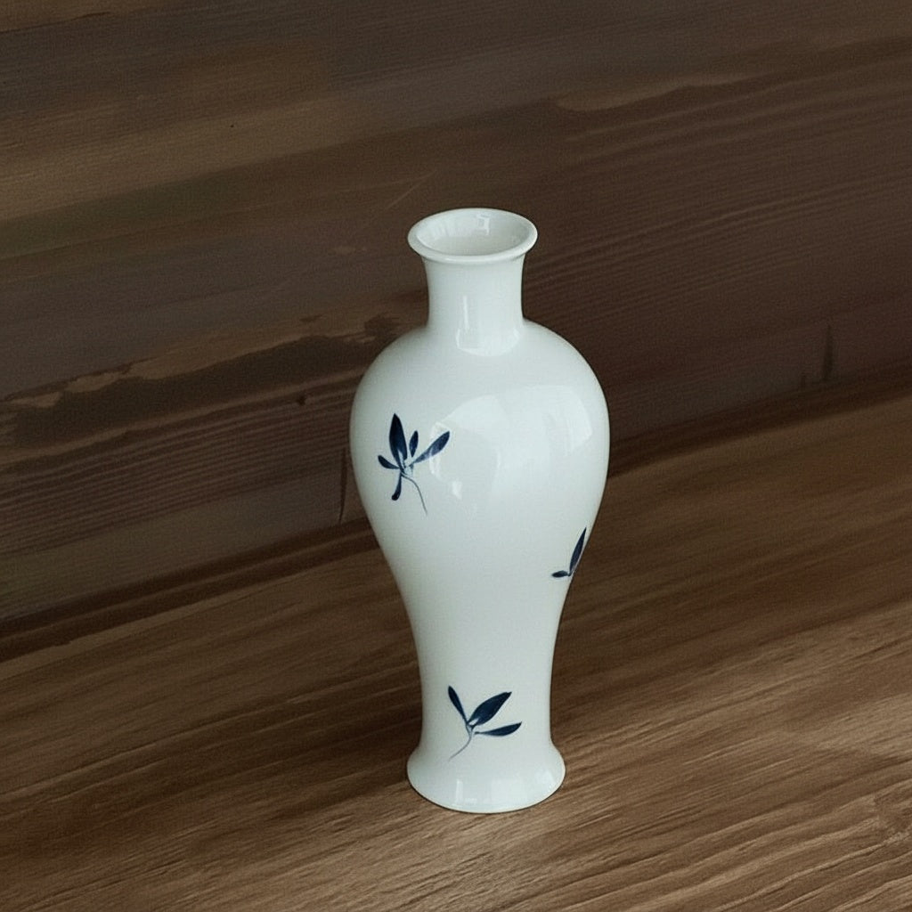 White ceramic botanical vase on wooden shelf