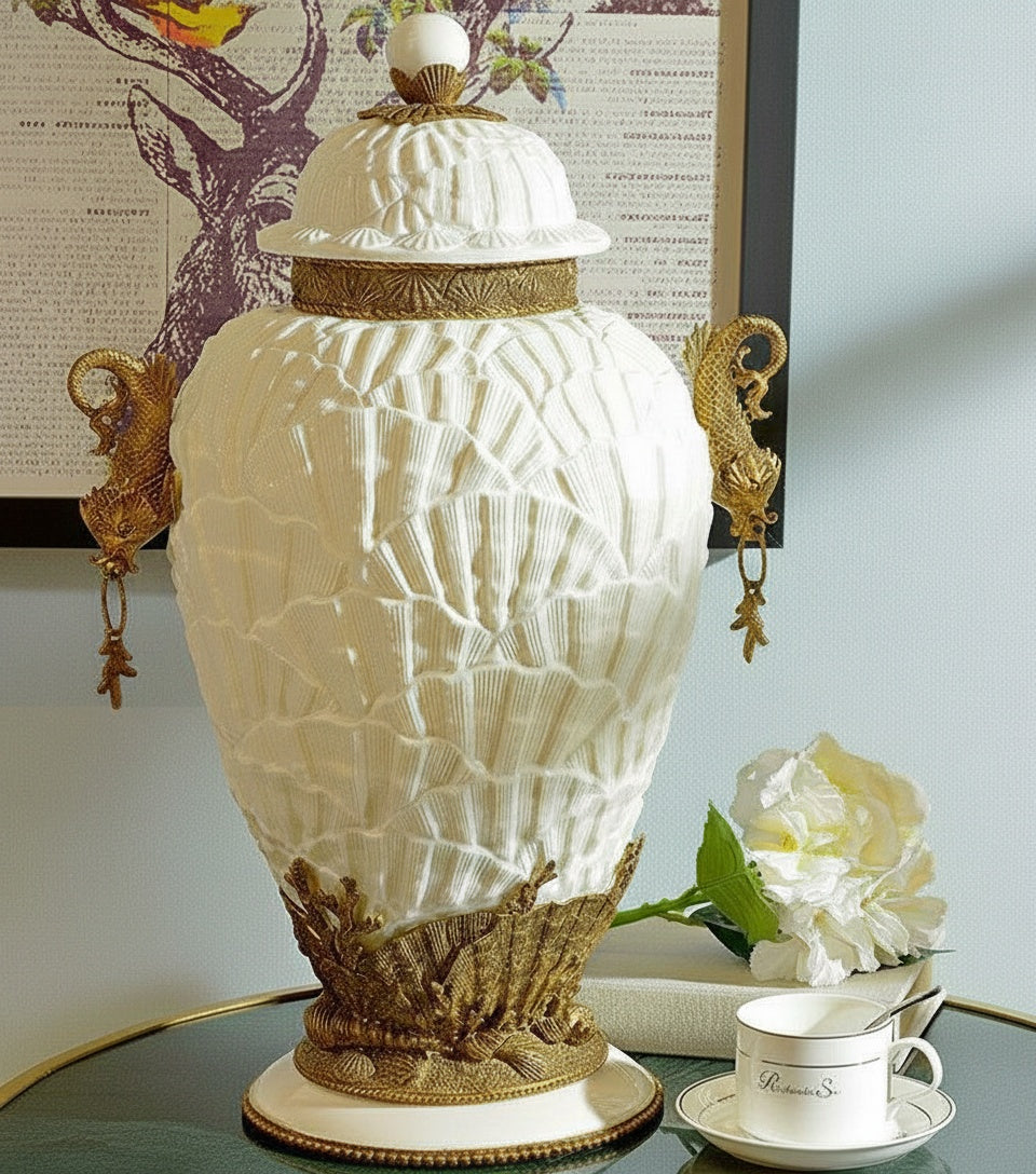Front view of white ceramic shell textured jar with brass handles