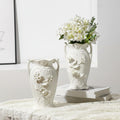 White ceramic vase with 3D floral relief details on lace tablecloth