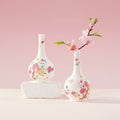 Two floral ceramic bottle vases displayed together