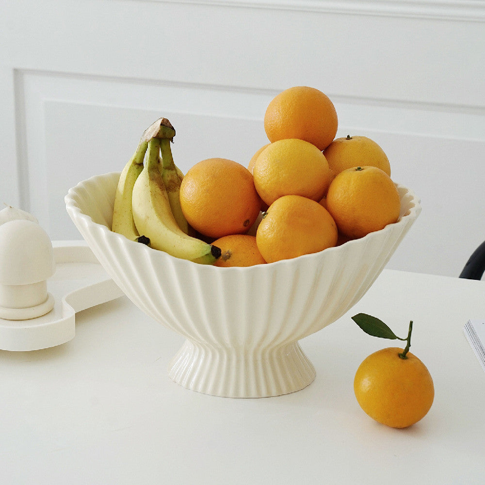 White ceramic fluted pedestal bowl filled with fresh fruit