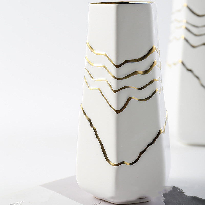 Close up of white geometric vase with gold detailing