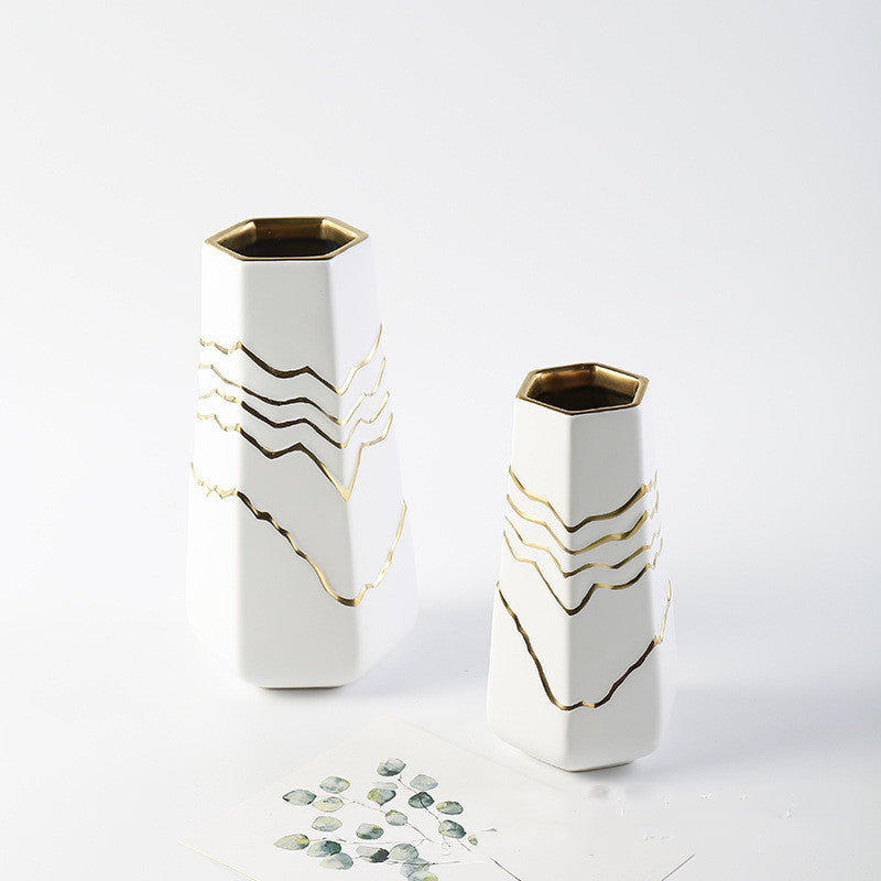 Angled view of hexagonal ceramic vases with gold lines