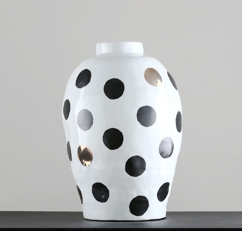 Front view of white vase with black and gold dots