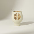 Front view of matte white ceramic vase with cane webbing detail