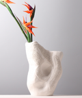 Angled view of white organic vase with flowers