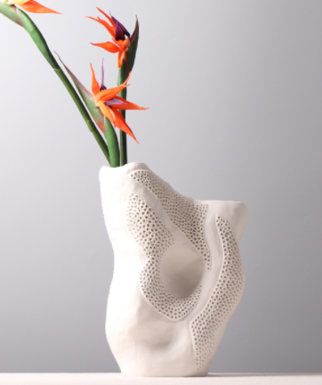 Angled view of white organic vase with flowers