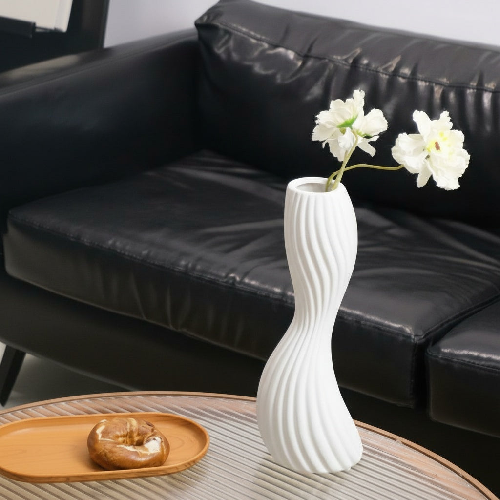 White ceramic twisted spiral vase with flowers on coffee table