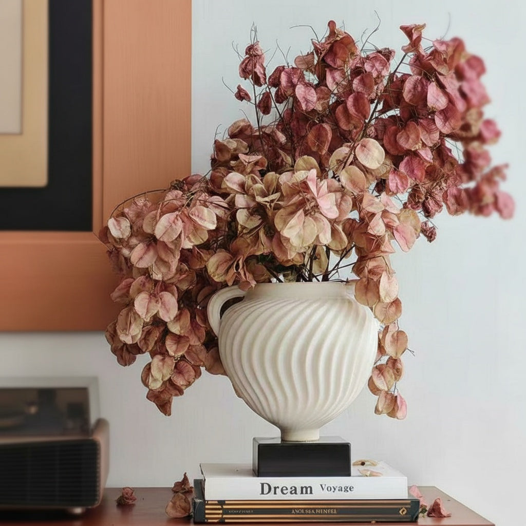 White fluted urn vase styled with dried pink botanicals