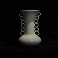 Front view of white ceramic vase with ring handles on black background