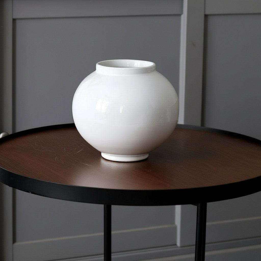 White Glazed Ceramic Spherical Vase on a dark wooden table