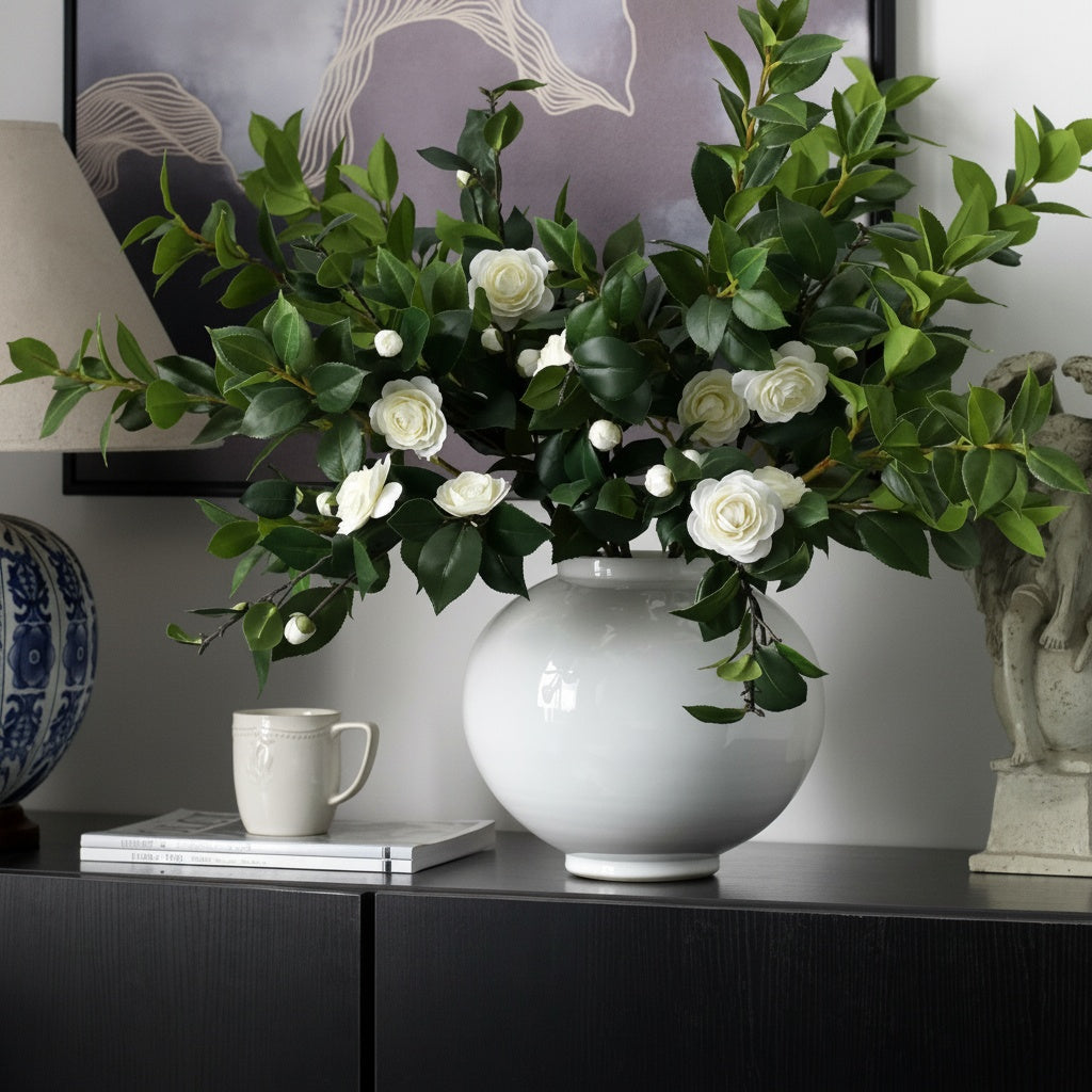 White Glazed Ceramic Spherical Vase styled with white flowers and foliage