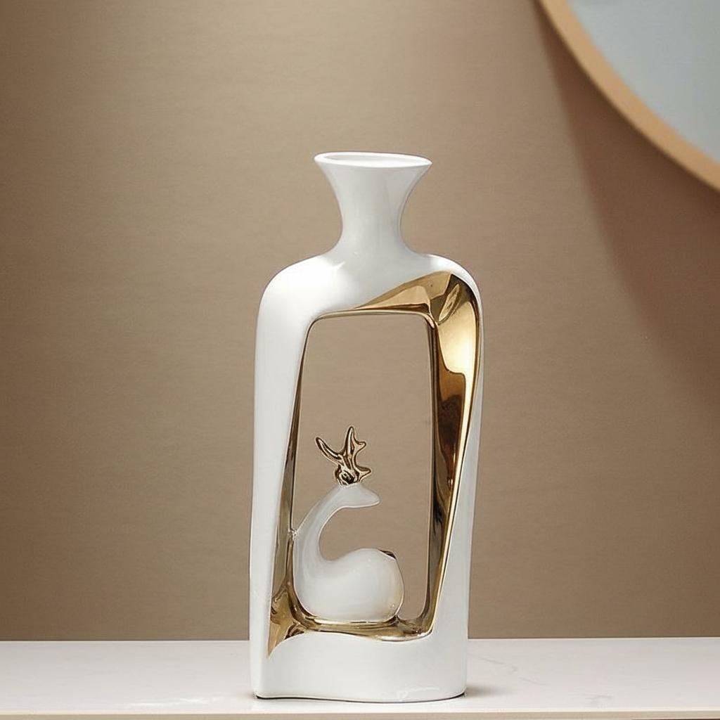 Tall white and gold ceramic vase with abstract cutout and deer figurine