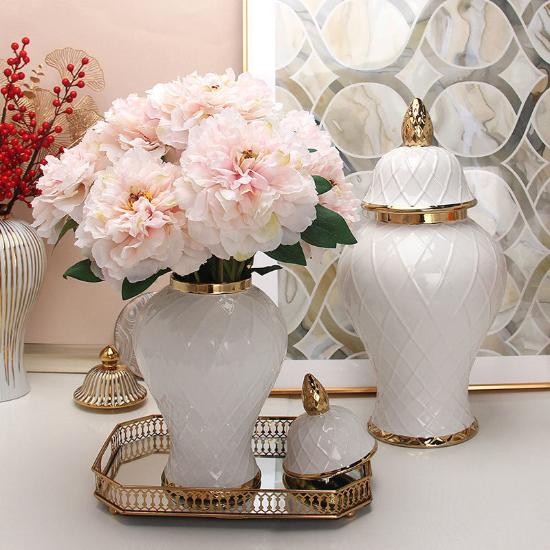 Lifestyle shot of white ceramic ginger jars with flowers and gold accents