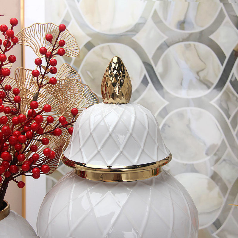 Close up detail of gold pinecone finial on white lid