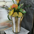White and gold leaf glass vase with floral arrangement