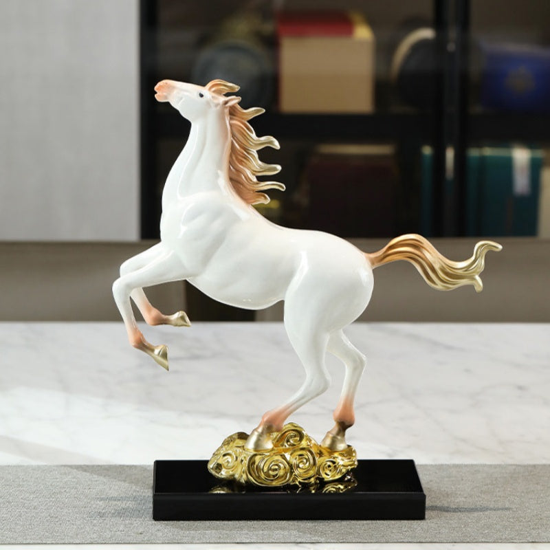 Side profile of white and gold rearing horse sculpture on black base
