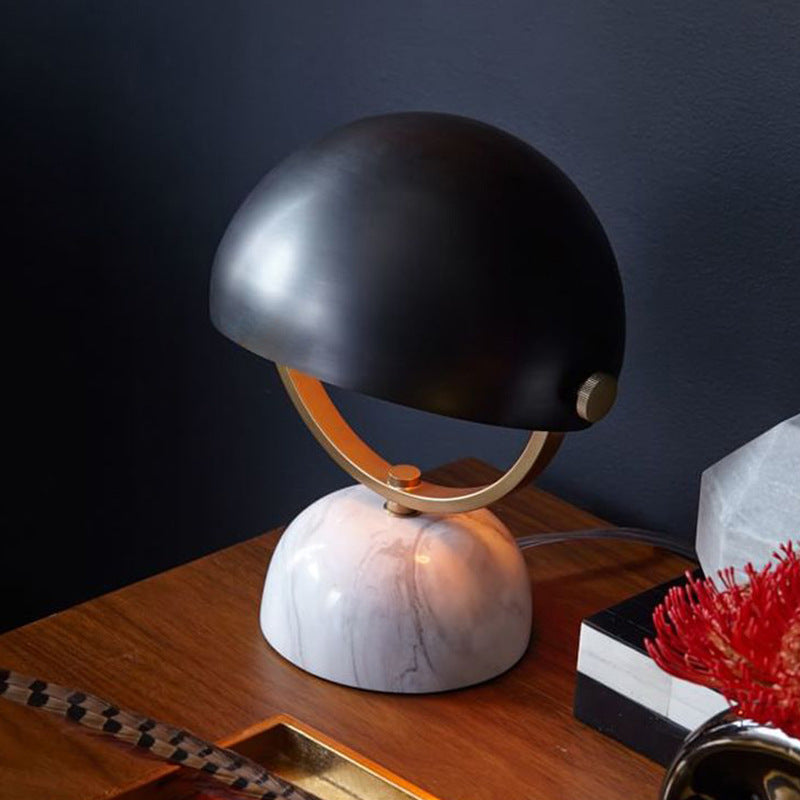 Angled view of black dome lamp on wooden table
