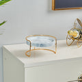 Front view of white marble and gold elevated tray on white surface