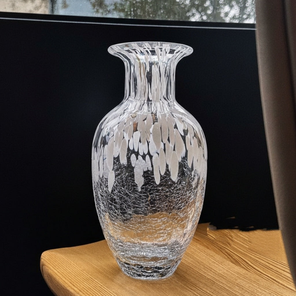 Empty clear glass vase with white artistic strokes on wooden table