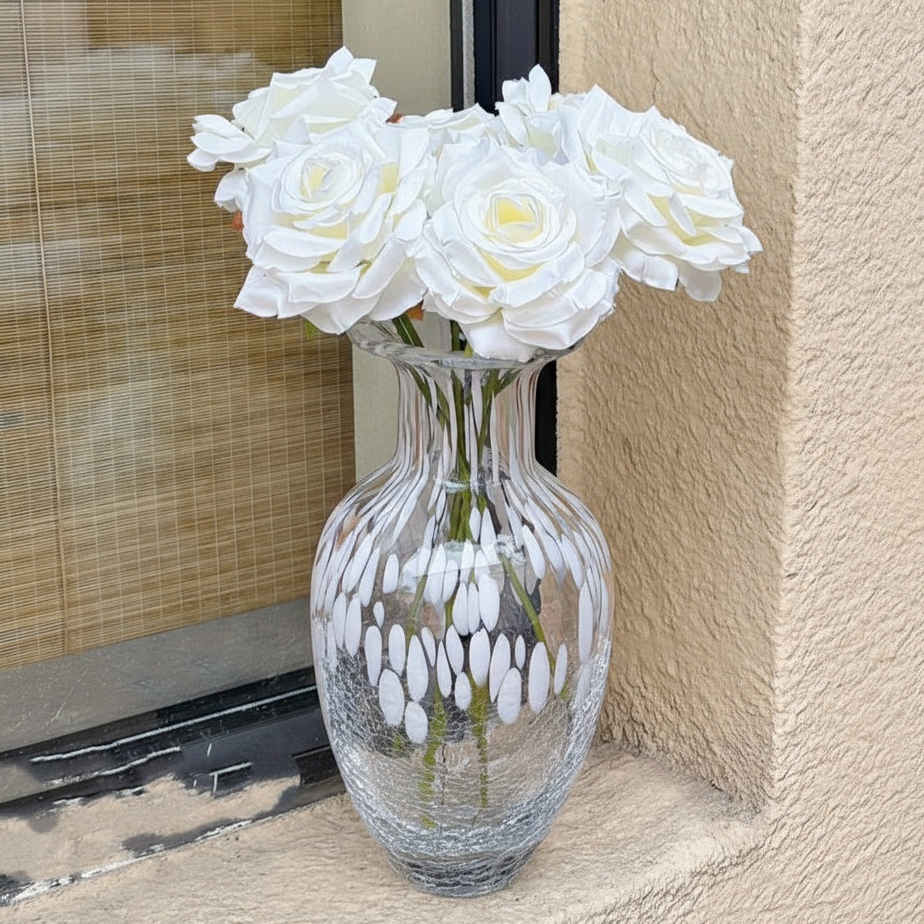 Full view of white patterned glass vase with flowers near window