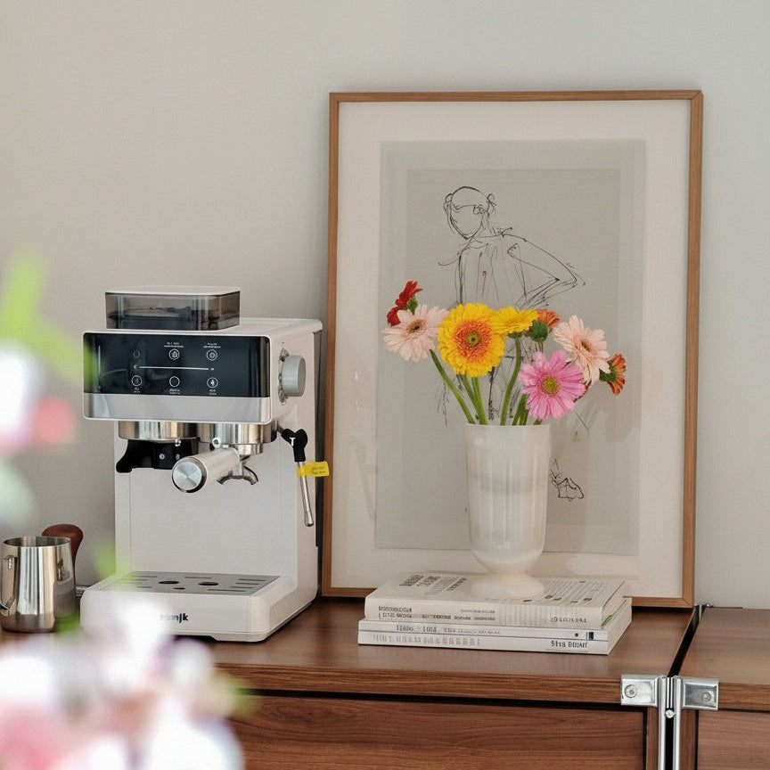 White stone pedestal vase with colorful flowers near coffee machine