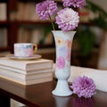 White porcelain floral pedestal vase displayed on a table with flowers