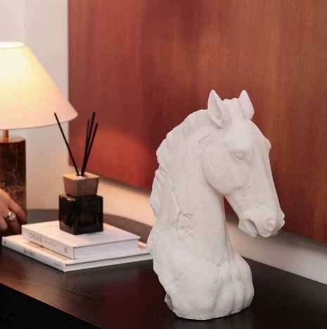 White resin horse head sculpture on dark wood table