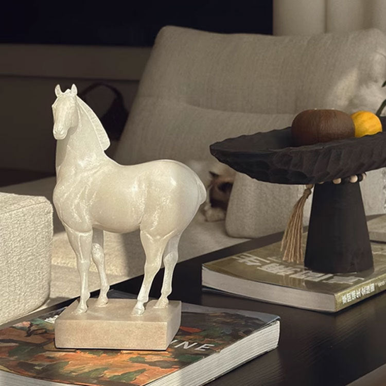 White horse statue styled on coffee table with books