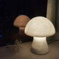 White ribbed resin mushroom lamp glowing in dark room