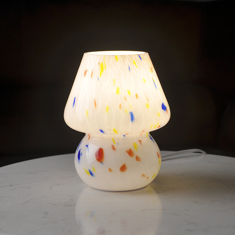 Night view of glowing speckled glass table lamp providing warm ambient light in a dark room