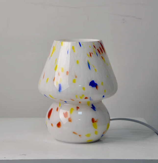 Studio shot of white speckled glass mushroom lamp isolated against a white background