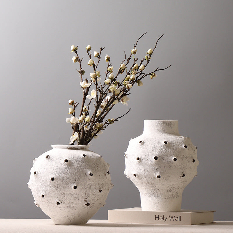 Pair of white textured sea urchin vases on table