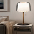 Front view of wood and glass table lamp on side table