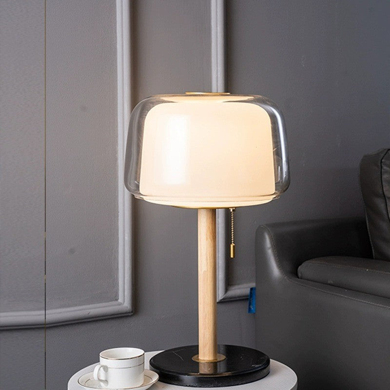 Illuminated glass table lamp with marble base in grey room