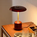 Front view of solid wood and burgundy glass table lamp on wooden desk