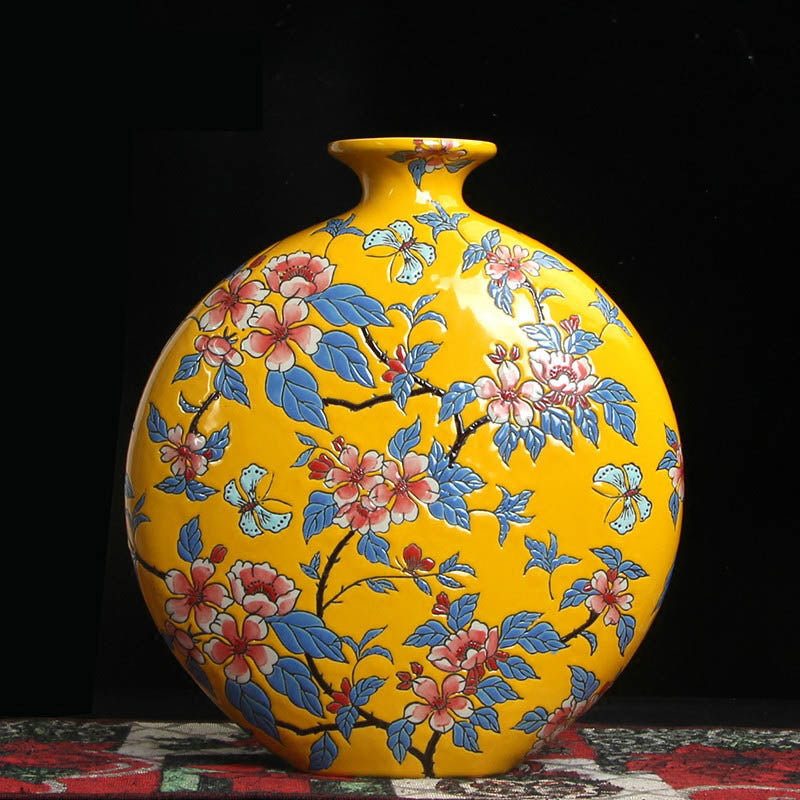 Front view of yellow ceramic moon flask vase with floral and butterfly patterns
