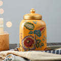 Front view of yellow floral ceramic ginger jar with gold lid