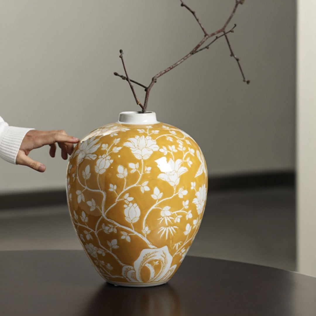 Hand touching yellow floral ceramic vase