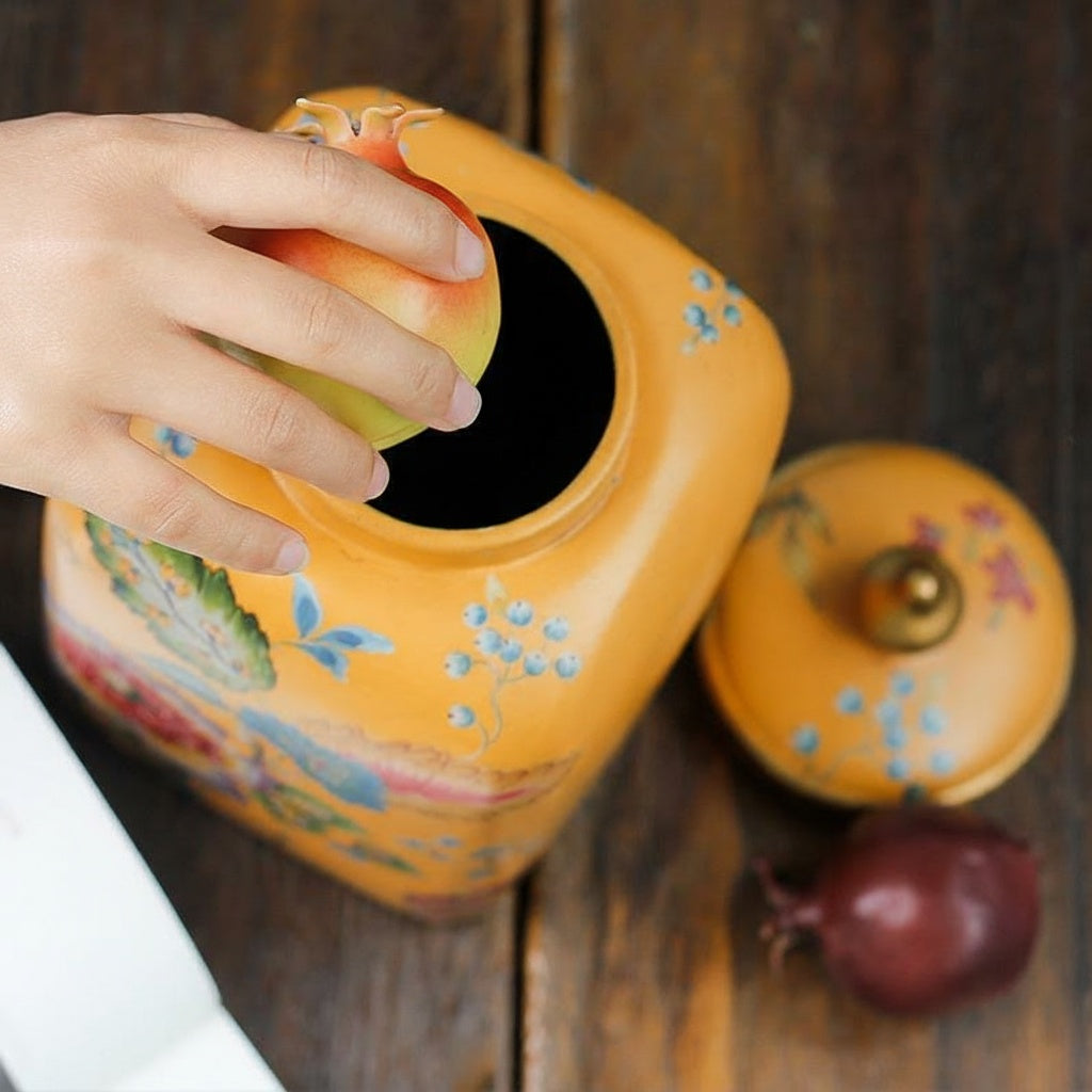 Top view of open ceramic jar with hand placing item inside