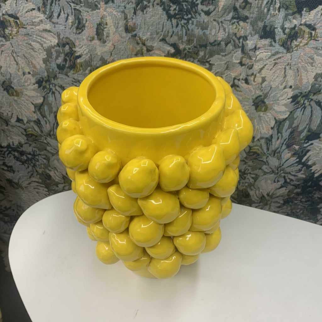 Top view of yellow glazed ceramic lemon vase showing round opening and raised lemon texture