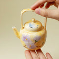 Yellow porcelain teapot with purple flowers