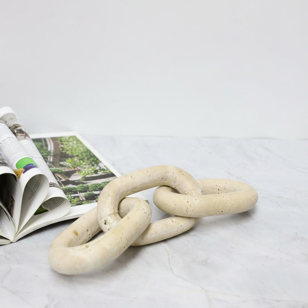 Lifestyle styling of travertine chain on open magazine