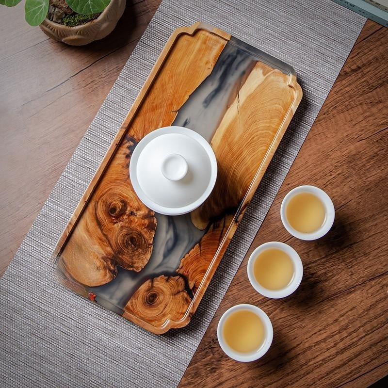 Overhead shot of resin tea tray with tea cup and pot on a textured table runner